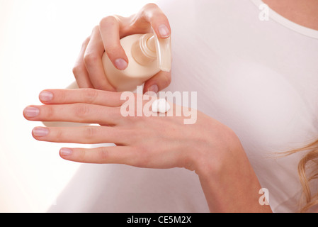 Frau eine Flasche auf ihre Hand Moisturizer Auspumpen Stockfoto