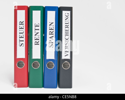 vier farbige Dateien aufrecht mit dem deutschen Label "Steuer", "Rente", "Sparen" Und "Versicherung" (Steuern, Rente, sparen, Versicherung) Stockfoto