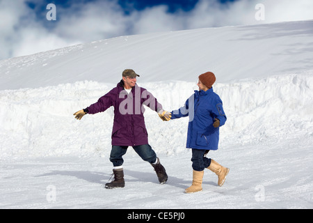 Älteres Paar Hand in Hand und Wandern im Neuschnee in Vermont Stockfoto