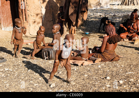 Himba-Frauen und Kinder in ihrem Dorf in der Nähe von Opuwo, Namibia Stockfoto