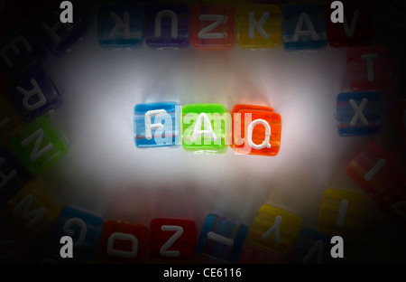 Text FAQ auf bunten Würfel über weiß. Buchstaben weiß zufällig verstreut Stockfoto