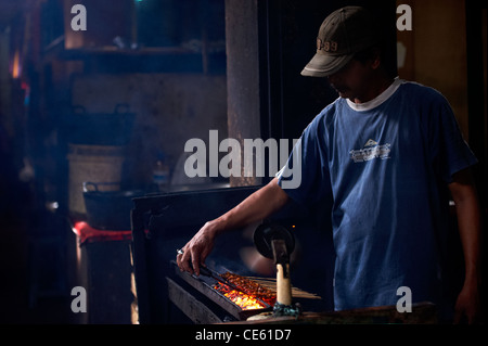 Balinesische Mann kochen Huhn Satys bei Ubud Märkte Bali Indonesien Stockfoto