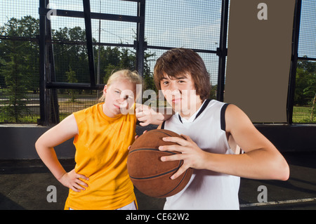 Zwei Teenager Basketball-Spieler posiert auf dem Kinderspielplatz im freien Stockfoto