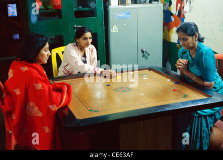 Indische Familie Frauen spielen carrom zu Hause ; Karom Tabletop Spiel ; Indien ; Asien ; MR#152 Stockfoto