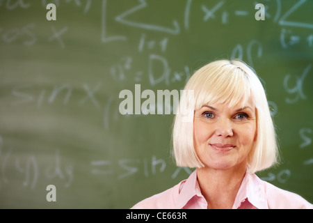 Porträt von blonden weiblichen Blick in die Kamera von Blackboard auf Hintergrund Stockfoto
