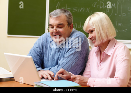 Porträt von reifer Mann und gealterte Frauen arbeiten mit Laptop während der Schulung Stockfoto