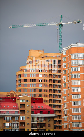 Architektonische abstrakt moderne Multi-Wohnungen bauen und Hebe Kran in einen Sonnenuntergang (Neuentwicklung) Stockfoto