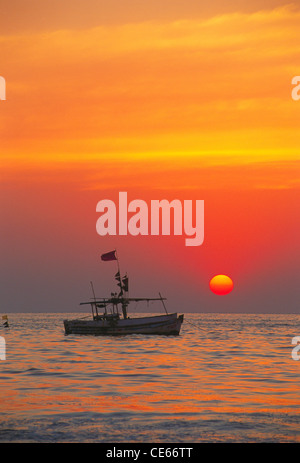 Farbenfrohen Sonnenuntergang mit Fischerboot; Juhu Strand; Bombay Mumbai; Maharashtra; Indien Stockfoto