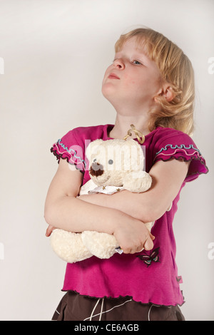 blonde kurzhaarige Mädchen Kind im Studio, 5 Jahre alt mit Teddybär Stockfoto