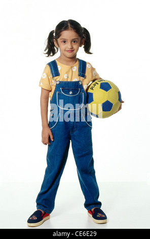 Indische junge kleine Mädchen Kind hält Fußball ; Indien ; Asien ; HERR#235 Stockfoto