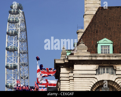 Das London Eye überragt County Hall und ein Souvenir-Stall mit Union Jack-Flaggen. Stockfoto