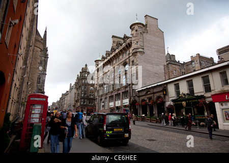 Geschäfte und Bars auf der High Street mit Blick auf die Kathedrale und das Schloss, die Royal Mile, Edinburgh Stockfoto