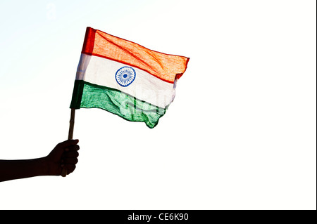 Indische mans Hände halten eine indische Flagge gegen einen hellen Hintergrund. Silhouette. Indien Stockfoto