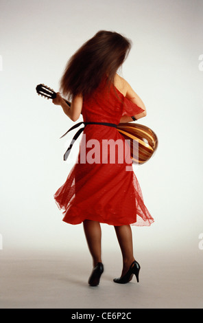 Frau spielt Musikinstrument Mandoline trägt rotes Kleid und schwarze Stiletto Schuhe ; MR#260 Stockfoto