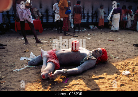 Indischer Bettler mit amputierten Bein; Asche bedeckt roten Lenden Tuch und roten Kopfbedeckung; Kerala; Indien; asien Stockfoto