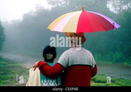 Indisches Paar, das unter Schirm im Monsunregen am Mahabaleshwar läuft; Maharashtra; Indien; Asien; Modell freigegeben Stockfoto