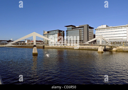 Eine Reihe von Gebäuden auf beiden Seiten des Tradeston-Fußgängerbrücke am Atlantik Quay auf dem Fluss Clyde in Glasgow Stockfoto