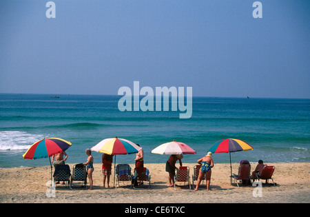 SDM 85974: Touristen sitzen unter bunten Sonnenschirmen Kovalam beach Kerala Trivandrum Indien Stockfoto