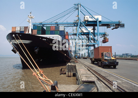 Große Krane laden Container von Lastwagen in Schiff bei Nhava Sheva ; Jawaharlal Nehru Port ; JNPT ; Bombay ; Mumbai ; Maharashtra ; Indien; Asien Stockfoto