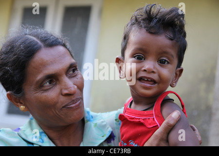 Stolze Mutter und Kind. Sie haben wenig Geld aber viel Liebe und Glück. Außerhalb der eigenen Wohnung in Sri Lanka gefangen. Stockfoto