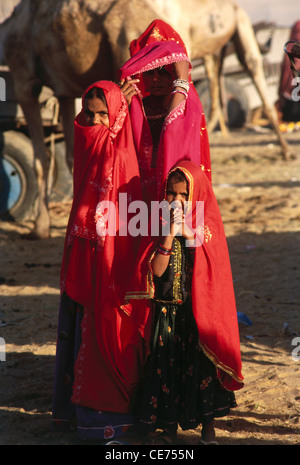 indische Frauen in ländlichen Gebieten Kinder Mutter Tochter rote Saree Pushkar fair Rajasthan Indien Stockfoto