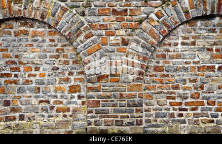 Alte Ziegeln stonewall aus ausgeschnittenen Felsen mit gewölbten Mauerwerk Stockfoto