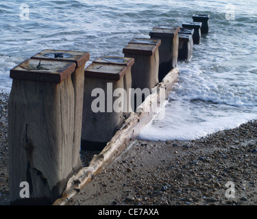 Eine Reihe von sieben Wellenbrecher Beiträge nach unten in die Flut führenden auf einem steinigen Strand in Südostengland Stockfoto