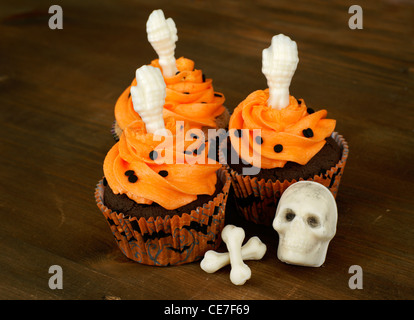 Muffins mit weißer Schokolade Skelettteile für Halloween dekoriert Stockfoto