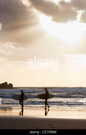 Surfer am Piha Beach bei Sonnenuntergang. Piha, Waitakere Ranges Regional Park, Auckland, Nordinsel, Neuseeland Stockfoto