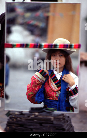 Spiegelbild einer jungen Chinesin in traditionellem tibetischem Gewand beim Besuch des Kulturparks für ethnische Minderheiten im südlichen Teil des Olympiaparks in Peking, China Stockfoto