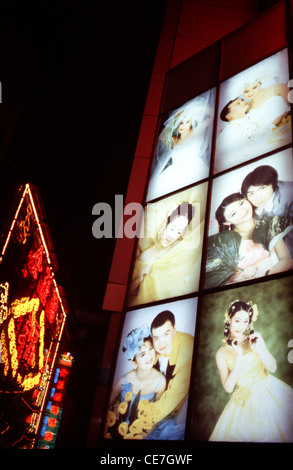 Chinesische Bräute und Bräutigam auf einer beleuchteten Plakatwand in Wangfujing Straße in Peking China Stockfoto