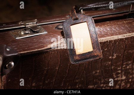 Alten Gepäckanhänger auf einen alten braunen Koffer. Stockfoto