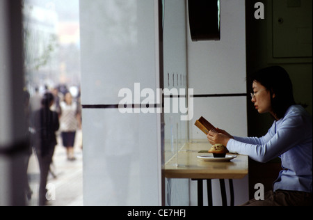 Eine Chinesin liest die Speisekarte in einem Café in der Fußgängerzone Wangfujing im Bezirk Dongcheng Peking China Stockfoto