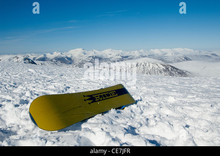 Snowboard, sitzt an der Spitze von Glencoe Ski Resort mit Blick auf Ben Nevis in helle Wintersonne Stockfoto