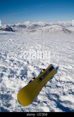 Snowboard, sitzt an der Spitze von Glencoe Ski Resort mit Blick auf Ben Nevis in helle Wintersonne Stockfoto