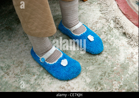 Ältere Frau tragen Socken & gestrickte Hausschuhe, halten warm und gemütlich im winter Stockfoto