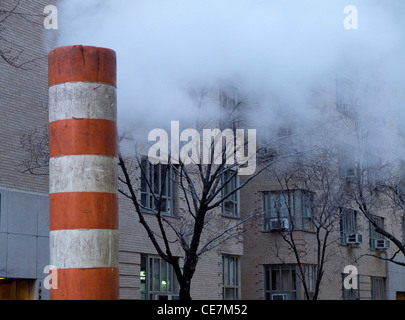 Dampf entweicht Schachtabdeckung Stockfoto