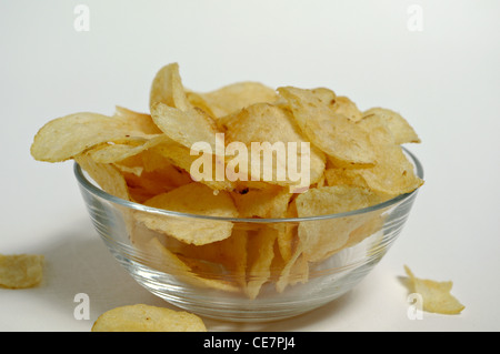 Kartoffel-Chips sitzen in eine Glasschüssel auf einem weißen Hintergrund. Stockfoto