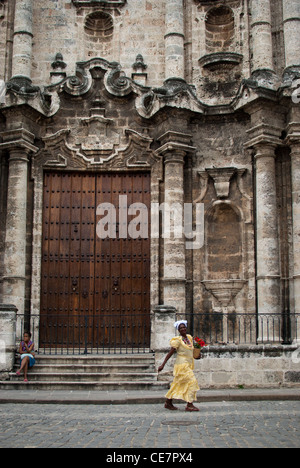 Verkauf Blumenmädchen vorbei Catedral de San Cristobal in Plaza De La Catedral La Habana Vieja, Havanna, Kuba Stockfoto