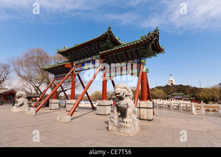 Eingangstor in Beihai Park Peking China, mit der weißen Pagode im Hintergrund. Stockfoto