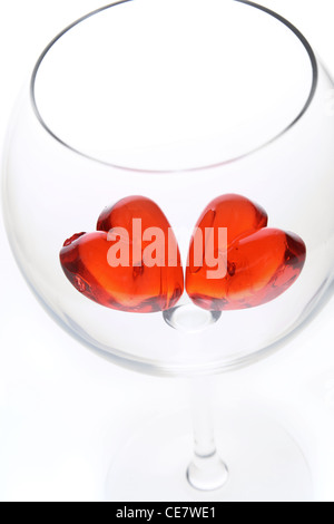 Rote Jelly Herzen im Glas Wein. Stockfoto