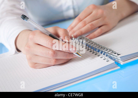 Zarte Frauenhand ab, um Notizen in ein Tagebuch Stockfoto