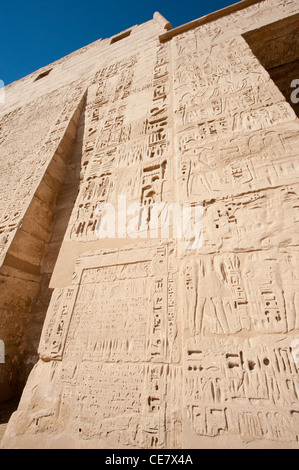 Ägyptische Hieroglyphen Schnitzereien und Malereien an der Wand des alten Tempels von Medinat Habu in Luxor Stockfoto