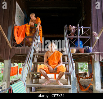 Zwei kambodschanische Mönche sitzen auf den Stufen zu ihrem Haus in Siem Reap, Kambodscha Stockfoto