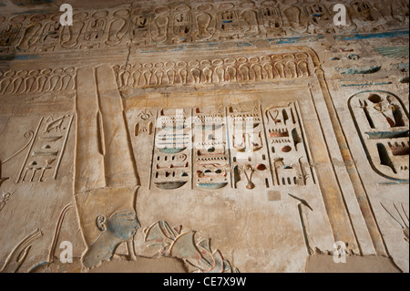 Ägyptische Hieroglyphen Schnitzereien und Malereien an der Wand des alten Tempels von Medinat Habu in Luxor Stockfoto