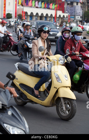 Intelligente junge Frau auf Motorroller in der Innenstadt von Ho Chi Minh Vietnam Stockfoto