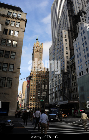 Blauer Himmel Wolkenkratzer Porträt, Sherry Netherland Hotel, Menschen überqueren West 57th Street an der Kreuzung 5th Avenue in New York Stockfoto