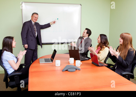 Business-Team motiviert durch positive Moderatorin, Clapping Mitarbeiter Stockfoto