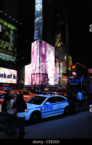 Neon Nachtporträt, in Richtung West 46th Street, Verkehr Menschen Polizist NYPD Polizeiauto, 7th Avenue, Times Square, New York Stockfoto