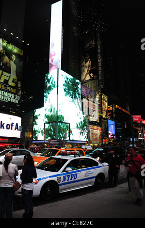 Nacht Neon Porträt Verkehr Menschen NYPD Polizist Polizeiauto geparkt 7th Avenue, in Richtung West 46th Street, Times Square, New York Stockfoto